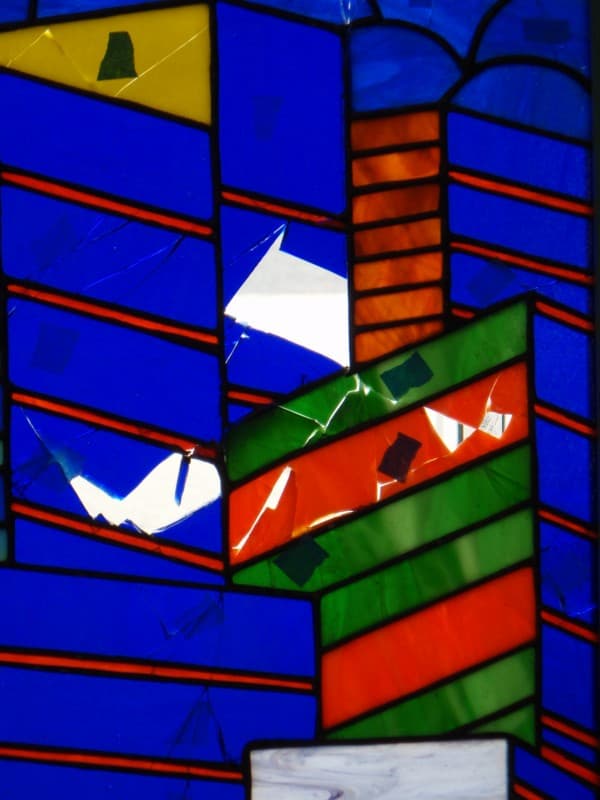 Closer view of broken stained glass pieces marked in blue tape