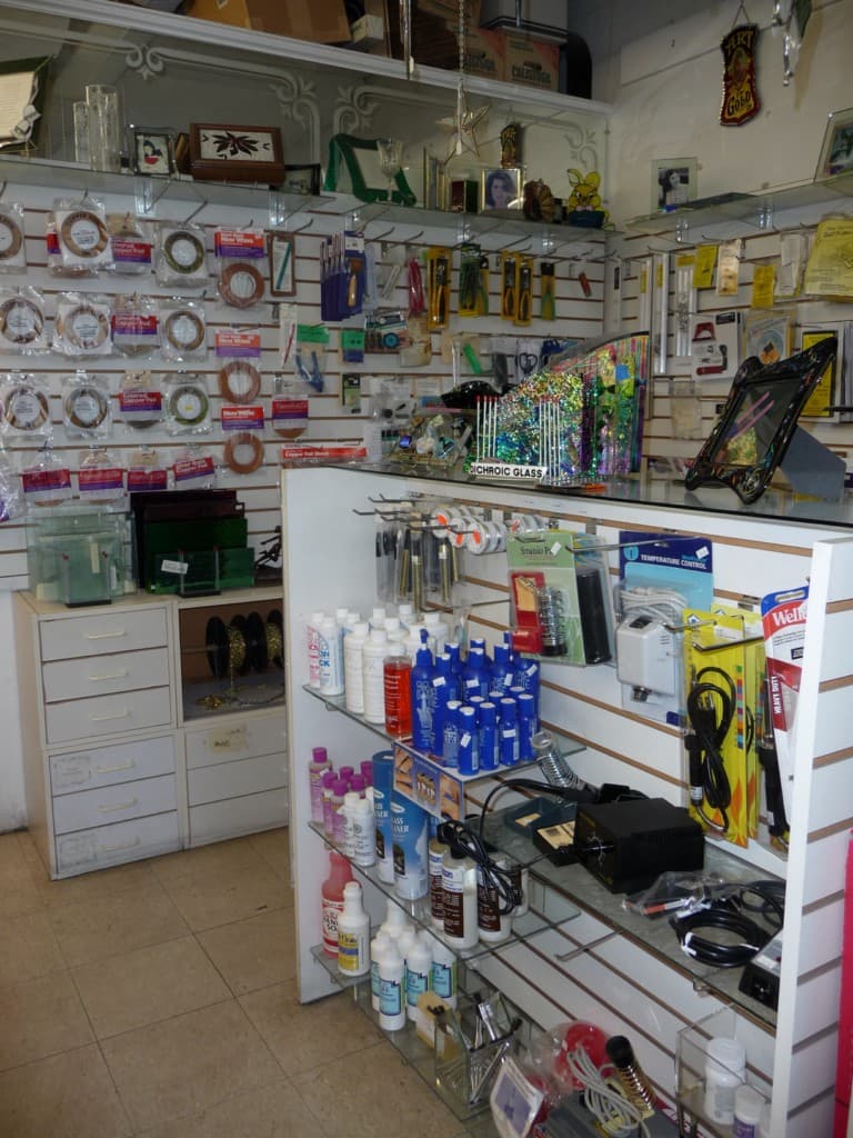 Wall of art glass supplies displayed in the Allen Kenoyer Glass studio